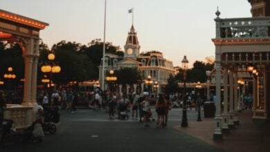 People walking on Main Street, U.S.A., at Disneyland Park at dusk.