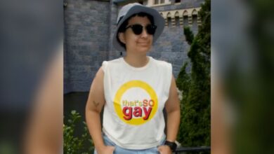 A person wearing a bucket hat, sunglasses, and "that's so raven" parody shirt reading "that's so gay." Disney security questioned this outfit choice.