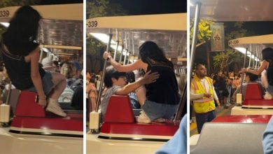 A woman climbs on the Disneyland Tram
