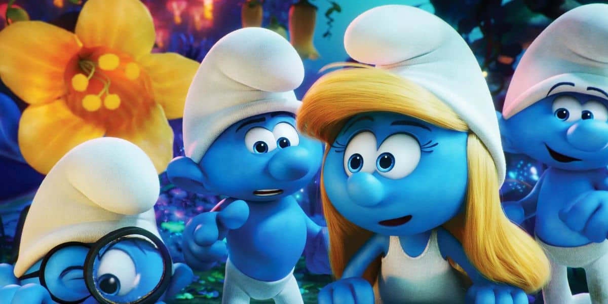 Four animated blue Smurfs, including one with blonde hair and another with glasses, stand together in a colorful forest with large yellow flowers in the background. They appear curious and engaged.