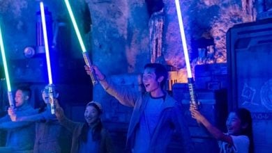 Four people with lightsabers at Savi's Workshop in Star Wars: Galaxy's Edge.