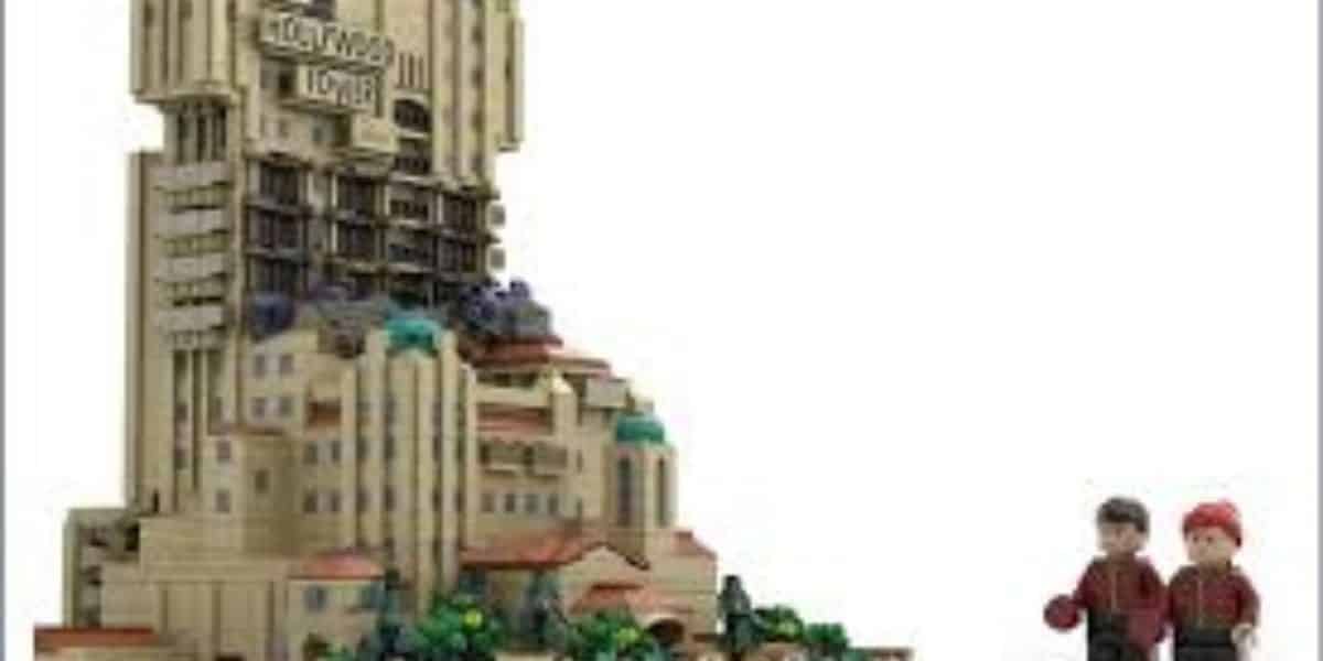 A LEGO model of the Hollywood Tower Hotel with two LEGO minifigures standing nearby, all set against a plain white background.