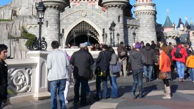 A crowd of people walk toward Sleeping Beauty Castle at Disneyland Paris.