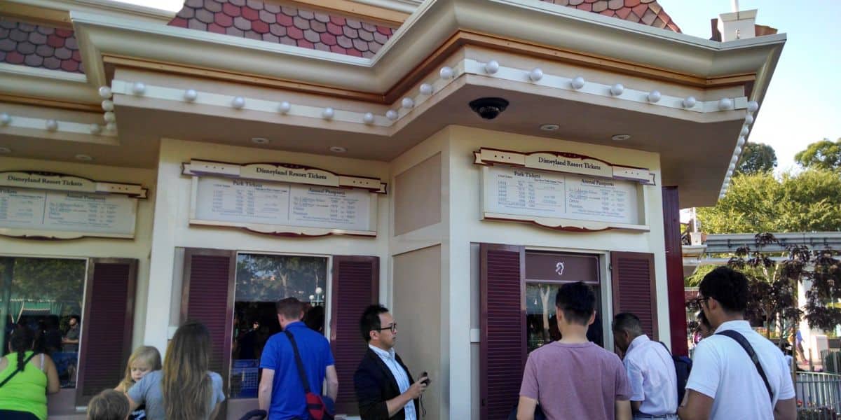 People buying theme park tickets at a booth at Disneyland Resort