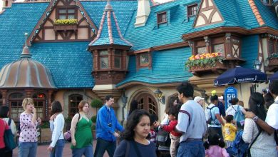 A crowd of people walks in front of Pinocchio Village Haus at Magic Kingdom Park