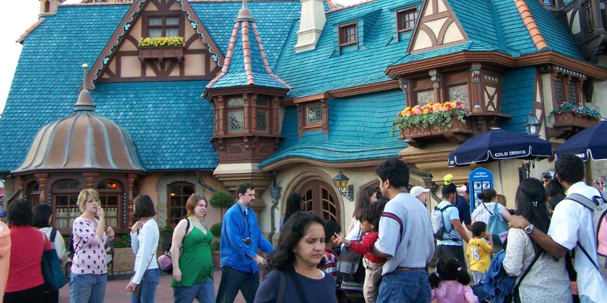 A crowd of people walks in front of Pinocchio Village Haus at Magic Kingdom Park