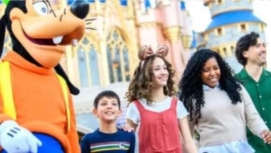 a family with goofy in front of cinderella castle in disney world's magic kingdom park