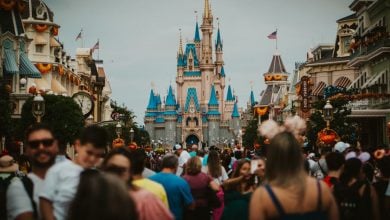 A large crowd of people walk along Main Street in Walt Disney World Resort