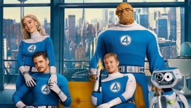 Cast of 'The Fantastic Four: First Steps' cast wearing blue suits, sitting on a couch