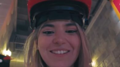 A smiling woman waiting in line for Mario Kart: Bowser's Challenge at Epic Universe.
