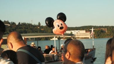 A Mickey Mouse balloon hovers above guests on a ferry boat at Walt Disney World Resort.