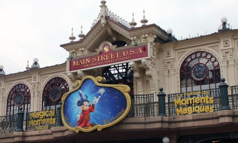 Crowds of guests walking through Disneyland Park at Disneyland Paris with Sleeping Beauty Castle visible in the background.
