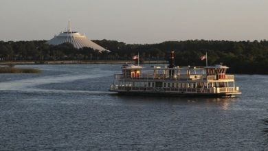 A ferry boat crosses the Seven Seas Lagoon at Walt Disney World Resort, with Space Mountain the background.