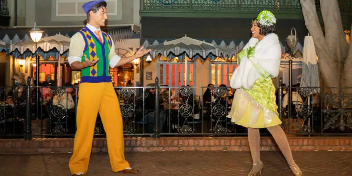 Princess Tiana and Prince Naveen smiling at each other at Disneyland Park.