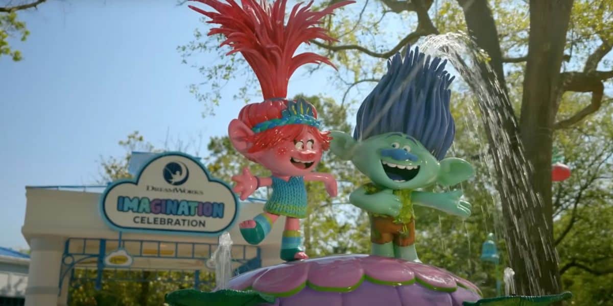 Poppy and Branch trolls with Imagination Celebration sign behind them in Universal