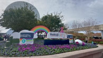 EPCOT’s Festival of the Arts bursts with color—rainbow arches and a giant paintbrush bloom in vibrant flower beds.