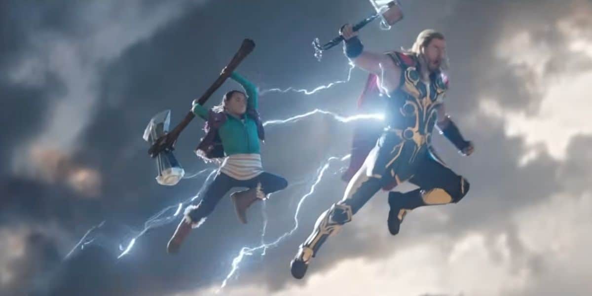 Thor and his adopted daughter, Love, jump in the air with mighty weapons in Thor: Love and Thunder film