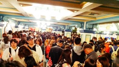 Guests line up inside a colorful, themed corridor, echoing the lively atmosphere of a Disney Parks attraction queue.