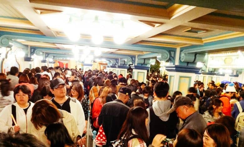 Guests line up inside a colorful, themed corridor, echoing the lively atmosphere of a Disney Parks attraction queue.