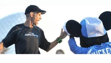 A runner high-fives Mickey Mouse at Disney World, sharing the magic and energy of a runDisney race celebration.