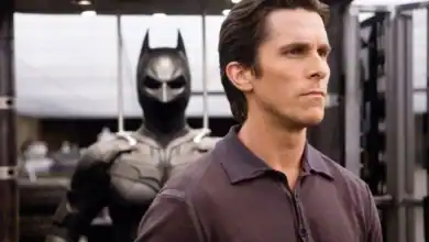 Bruce Wayne (Christian Bale) looking into the distance in front of the Bat suit in 'The Dark Knight'