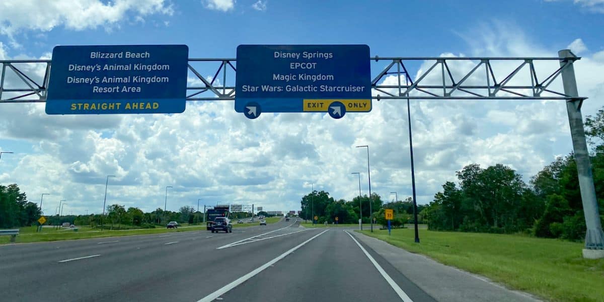 Blue road signs guide guests to Disney’s Animal Kingdom, EPCOT, Magic Kingdom, and Star Wars: Galactic Starcruiser at Disney World.