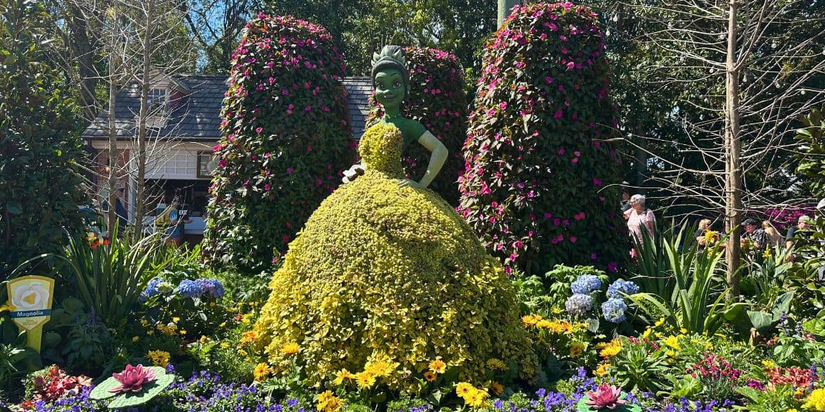 Princess Tiana topiary amid vibrant blooms and lush greenery at EPCOT International Flower & Garden Festival.