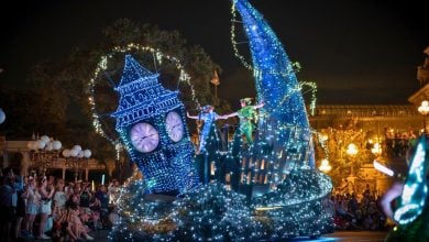 Peter Panโs glowing float dazzles Disneyland guests, with a sparkling clock tower and lively performers lighting up the night parade.