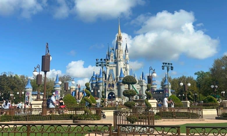 Cinderella Castle at Disney World, surrounded by guests, lush gardens, Tomorrowland rocks, and painters adding fresh Disney magic.