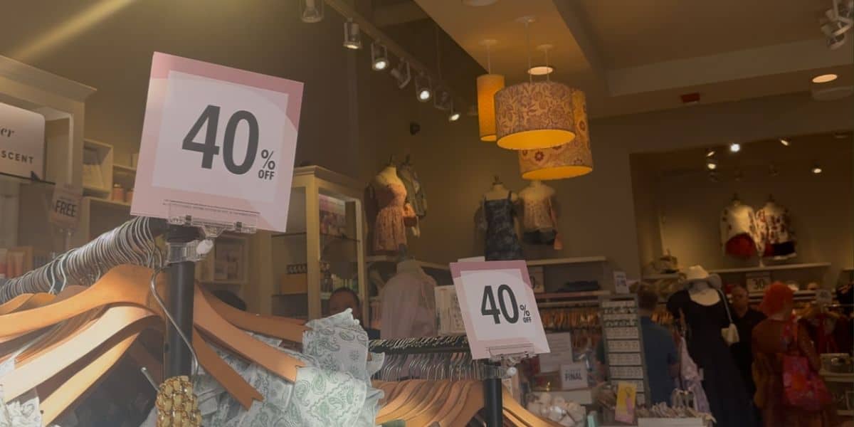 Vibrant store filled with 40% off sale signs and themed apparel displays—grab souvenir deals before this shop closes!.