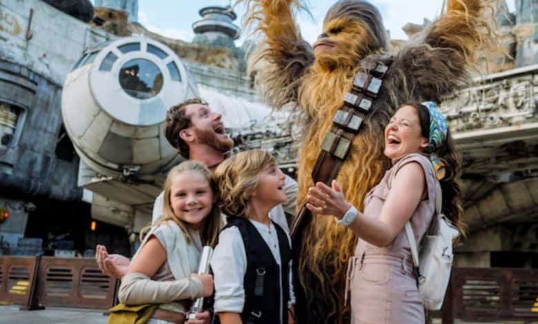 disney family poses with chewbacca at galaxy's edge in disney's hollywood studios park