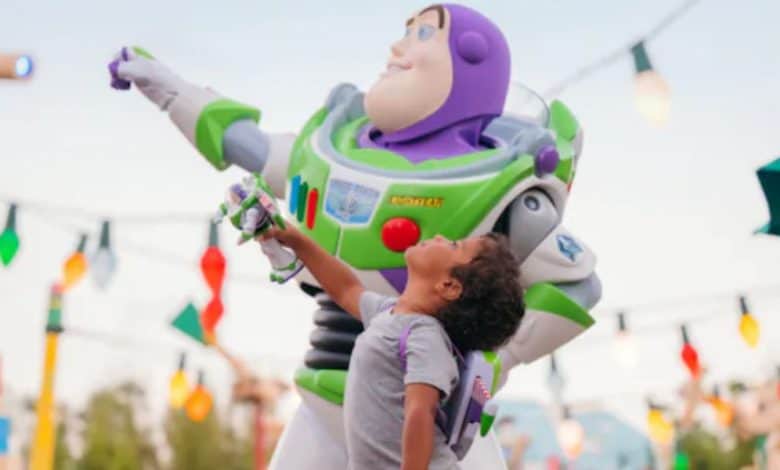 a young guest poses with Buzz Lightyear in Toy Story Land in Disney's Hollywood Studios park