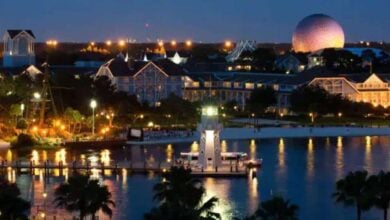 Disney’s Beach Club Resort shines at night with its lighthouse and dome, though fans debate the new mustard paint as possible primer.