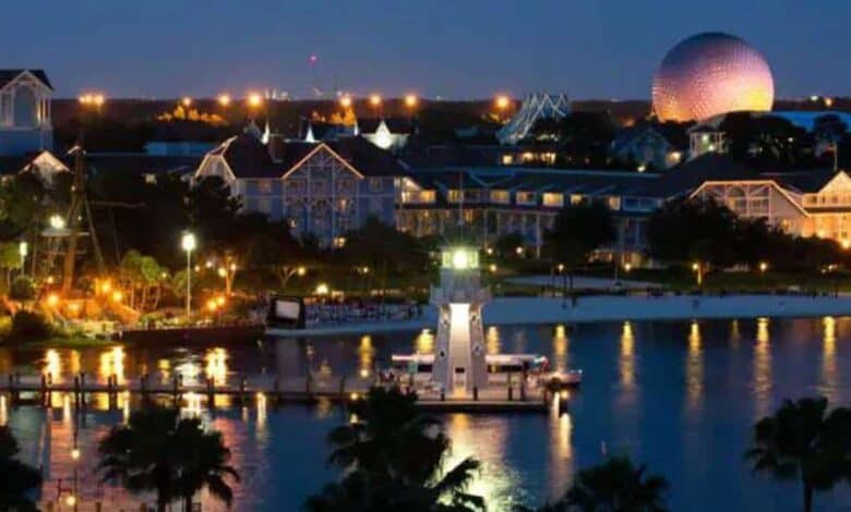 Disney’s Beach Club Resort shines at night with its lighthouse and dome, though fans debate the new mustard paint as possible primer.