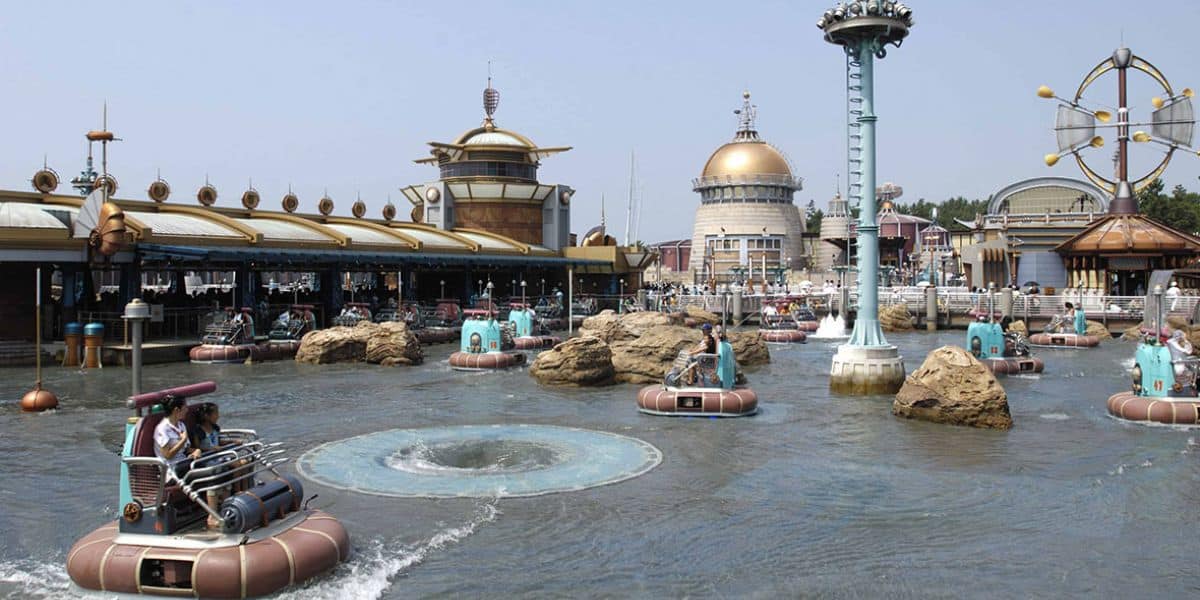 Guests pilot steampunk bumper boats through water at Tokyo DisneySea, with domed pavilions adding to the adventure ambiance.