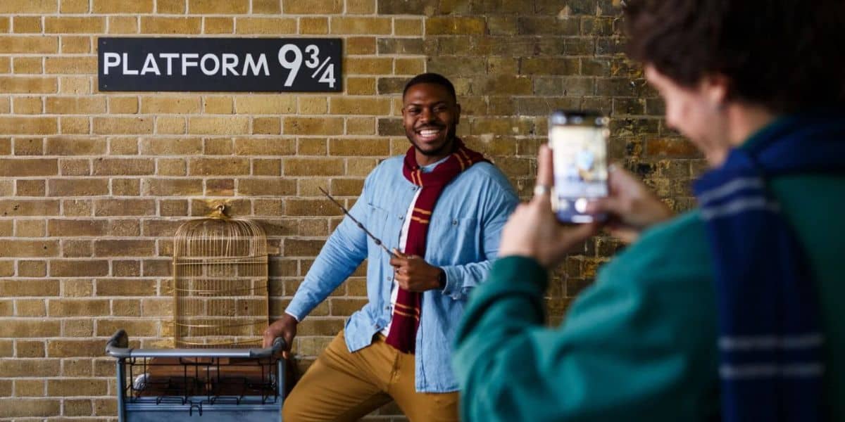 A fan pushes a trolley through Platform 9¾ at King’s Cross