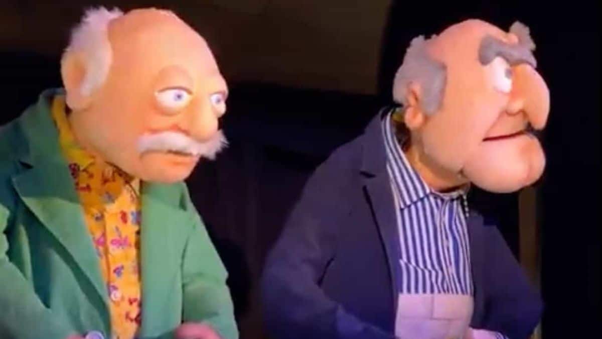 Statler & Waldorf animatronics in suits sit side by side, mustachioed and grumpy, just like at Muppets Rock โnโ Roller Coaster.