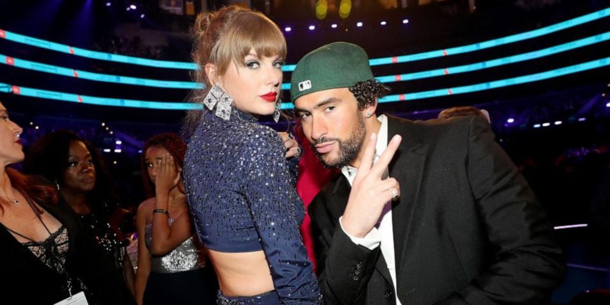 Celebrity duo dazzles at the awards, with one in a glittery blue look and the other in a green cap, spotlights shining behind them.