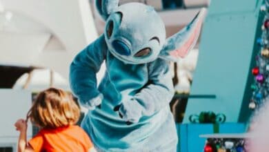 Disney's stitch mascot interacts with a young guest at disney world
