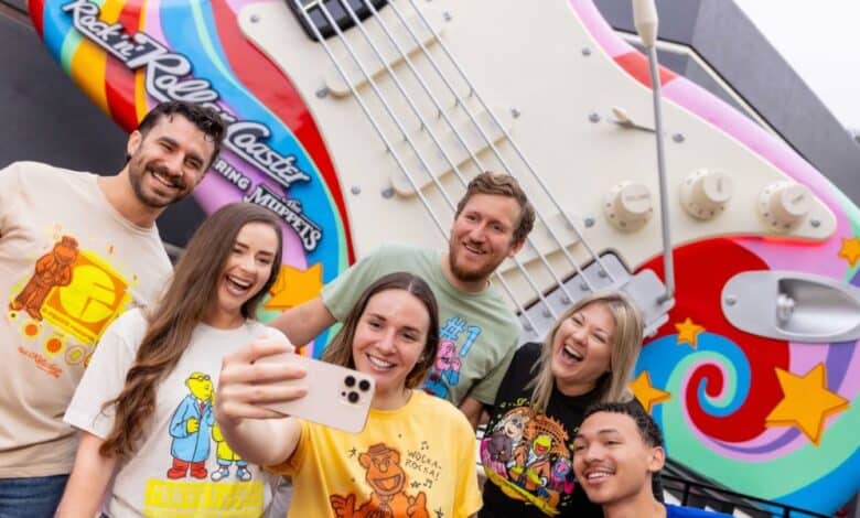 a group takes a selfie in front of rock n roller coaster starring the muppets guitar in disney's hollywood studios.