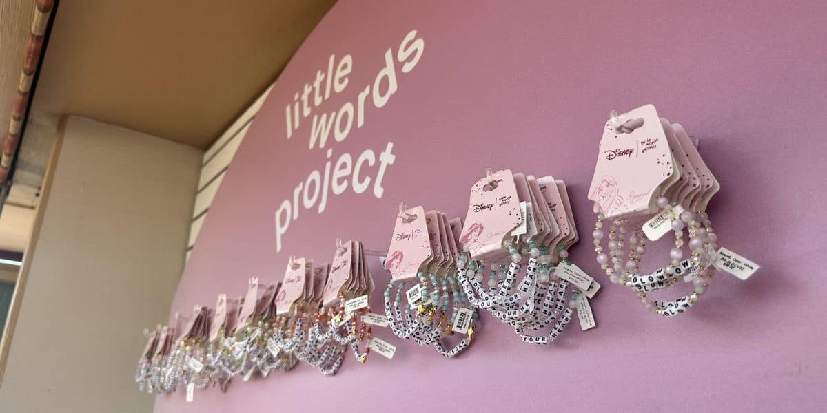 Little Words Project beaded bracelets showcased below a pink sign at Disney Springs during the weekend event this Sunday.
