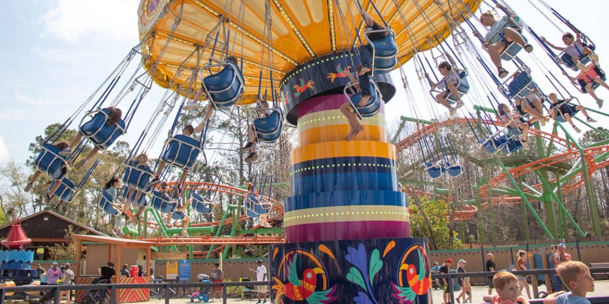 Families soar on the vibrant Swing Carousel at Six Flags Over Georgia, relishing thrills and sunny skies—and exclusive ticket deals.