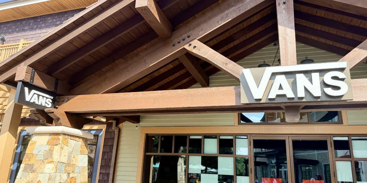 Vans storefront styled like a themed lodge, with wooden beams and two Vans signs welcoming visitors at the park’s retail area.
