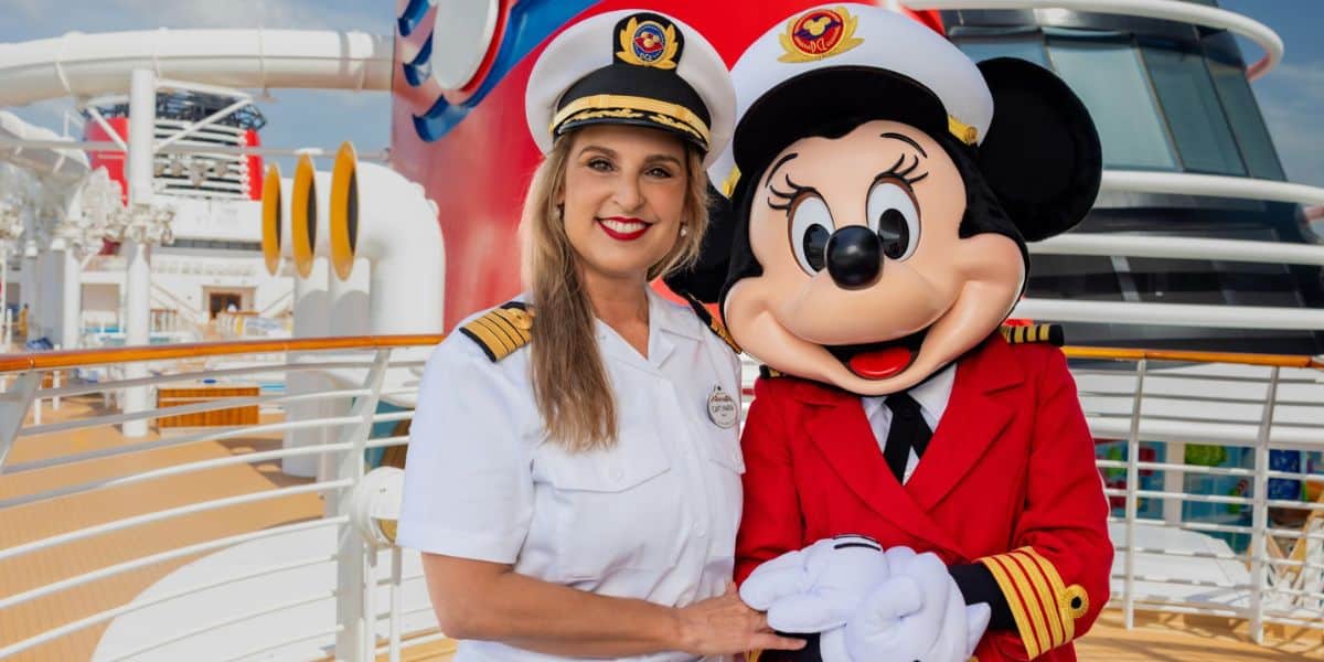 The Disney Cruise Line captain shares a cheerful moment with Minnie Mouse, who’s ready to set sail in her signature red captain’s coat and hat.