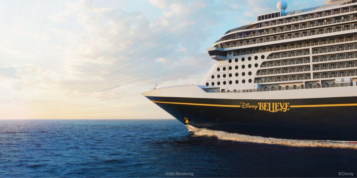 Disney Cruise Line’s "Disney Believe" glides across the ocean at sunrise, its iconic silhouette set against a magical sky, promising guests an unforgettable Disney adventure at sea.