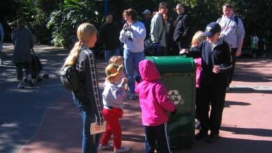 Families and kids gather by a talking trash can at EPCOT.