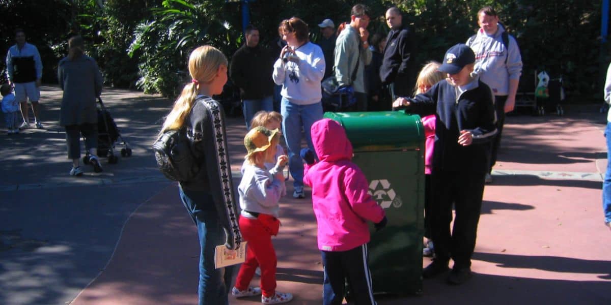 Families and kids gather by a talking trash can at EPCOT.