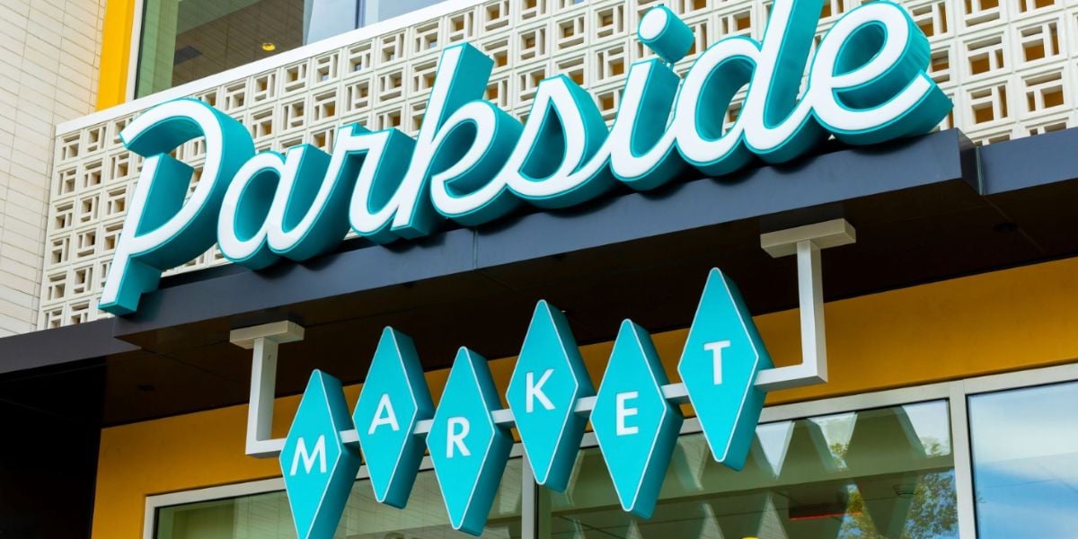 The bright turquoise "Parkside Market" sign pops against a stylish facade in Downtown Disney, setting a lively Disney atmosphere.