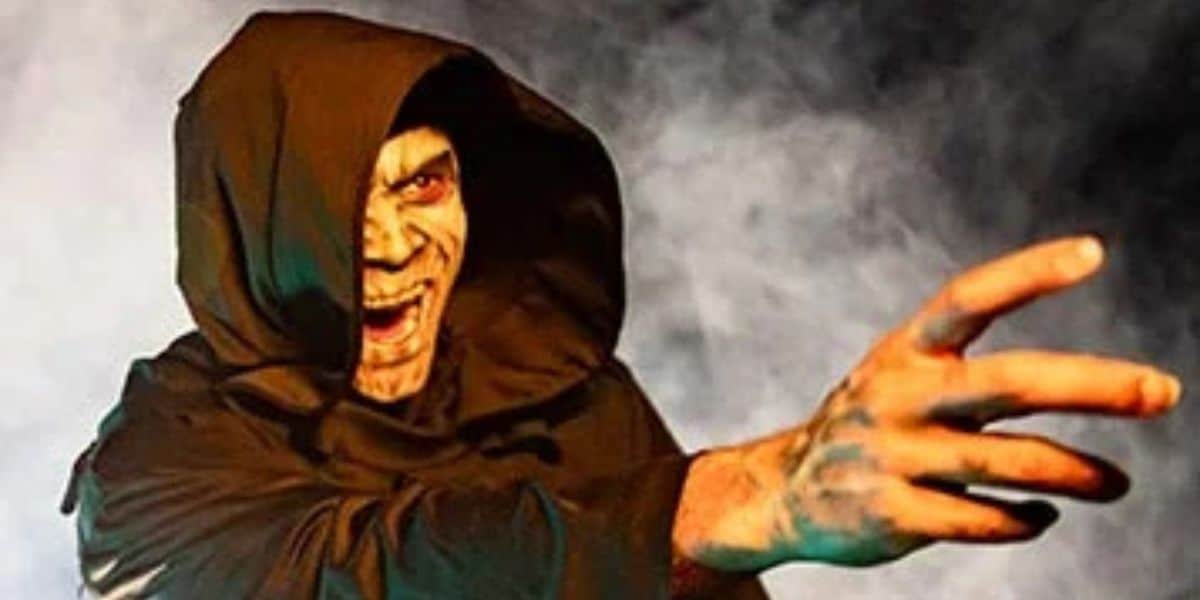 A hooded Horror Nights character lunges ominously through swirling mist, their chilling glare bringing the spine-tingling energy of Universal Orlando’s Halloween festivities to life.