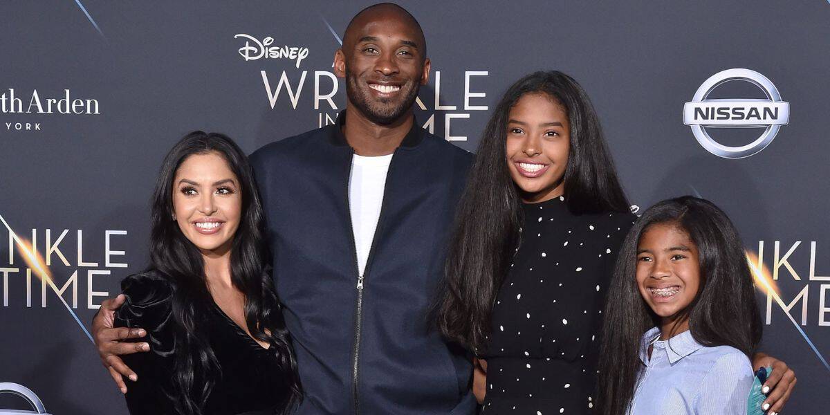 Four guests pose together on the red carpet at a Disney celebration, with signature Disney branding behind them, joining Vanessa Bryant for the special Disney Kobe Tribute honoring Kobe Bryant.
